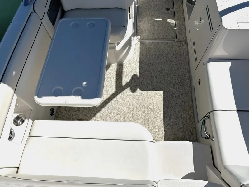 Slide: The Image of 2008 Sea Ray 290 Sundeck interior with seating and table, featuring beige upholstery. - 25