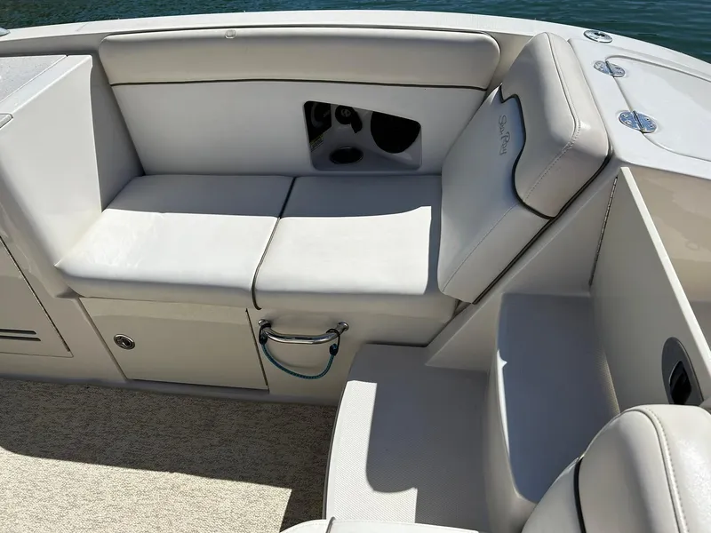Slide: The Image of 2008 Sea Ray 290 Sundeck interior seating with white upholstery and storage compartment. - 26