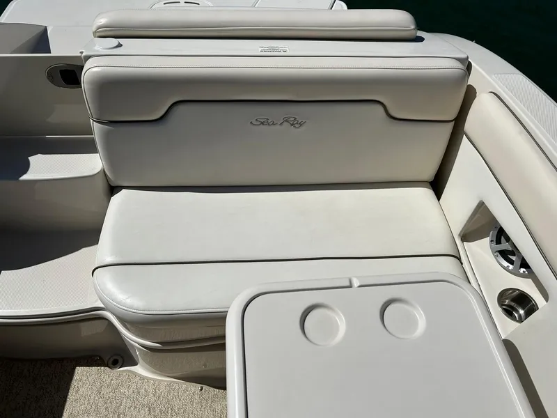 Slide: The Image of 2008 Sea Ray 290 Sundeck boat seating area with cup holders, featuring white upholstery. - 28
