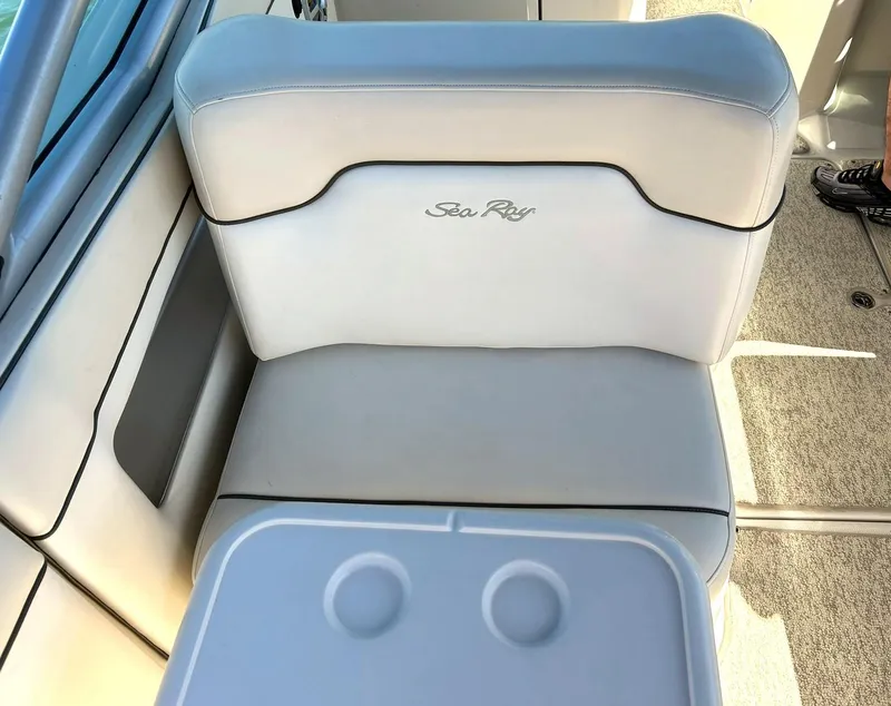 Slide: The Image of 2008 Sea Ray 290 Sundeck boat seat with cup holders, featuring white upholstery. - 29