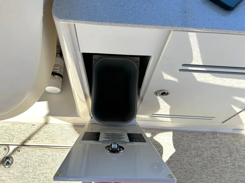 Slide: The Image of 2008 Sea Ray 290 Sundeck storage compartment with open door, revealing interior space. - 35