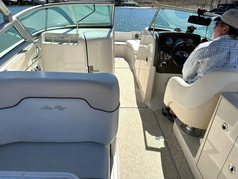 Slide: The Image of 2008 Sea Ray 290 Sundeck interior with helm and seating, on a sunny day. - 36