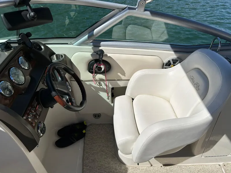 Slide: The Image of 2008 Sea Ray 290 Sundeck helm with steering wheel, gauges, and white captain's chair. - 38