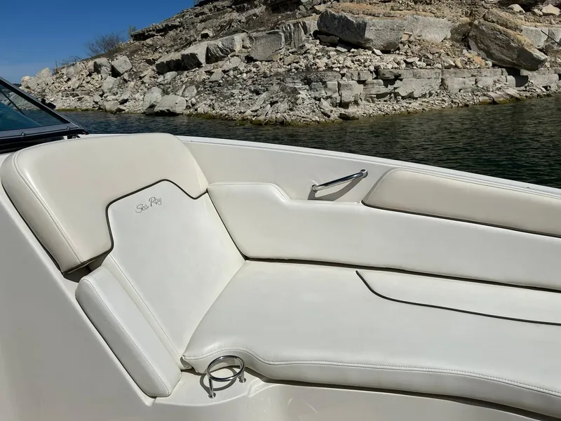 Slide: The Image of 2008 Sea Ray 290 Sundeck boat interior with white seating near rocky shoreline. - 48