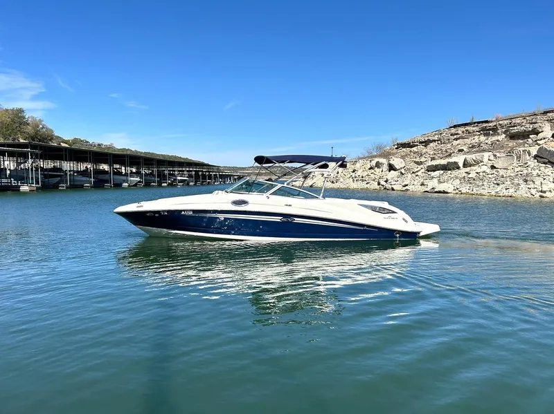Slide: The Image of 2008 Sea Ray 290 Sundeck boat on calm water under clear blue sky. - 6