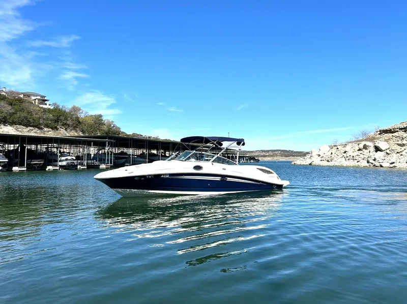Slide: The Image of 2008 Sea Ray 290 Sundeck boat on a serene lake under a clear blue sky. - 8