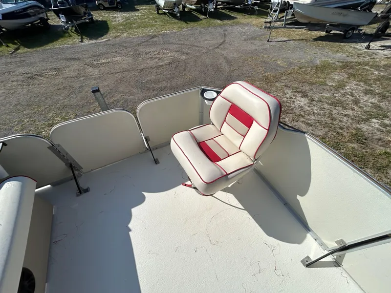 Slide: The Image of 2008 Fiesta Fish n Fun 16 Deluxe boat with red and white seating, parked on gravel. - 15