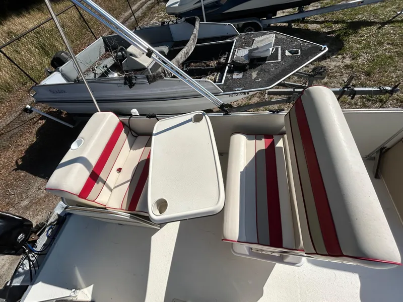 Slide: The Image of 2008 Fiesta Fish n Fun 16 Deluxe boat interior with red-striped seating and table. - 9