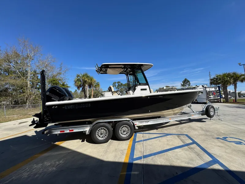 Slide: The Image of 2017 Everglades 273 Center Console boat on trailer, parked outdoors under clear blue sky. - 14