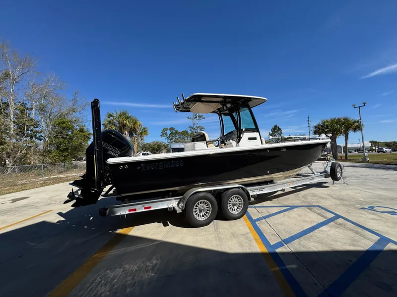 Slide: The Image of 2017 Everglades 273 Center Console boat on trailer, parked outdoors under clear blue sky. - 15