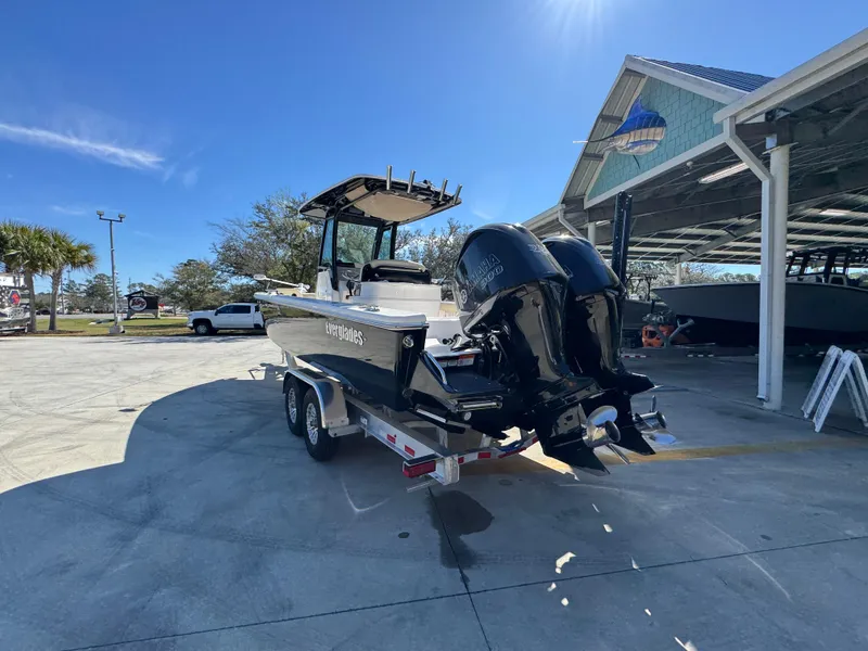 Slide: The Image of 2017 Everglades 273 Center Console boat on trailer, parked outdoors under clear blue sky. - 23