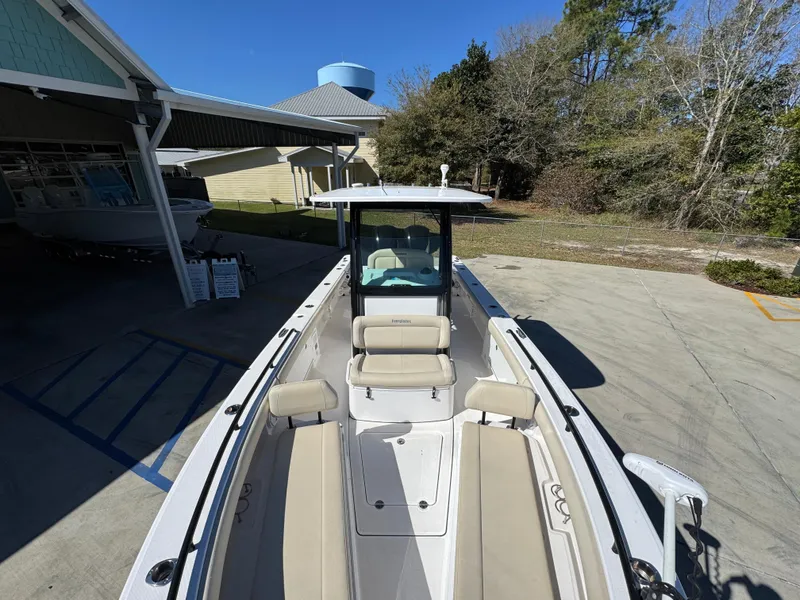 Slide: The Image of 2017 Everglades 273 Center Console boat with beige seating, parked outdoors. - 27