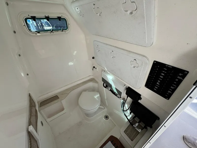 Slide: The Image of Interior of 2017 Everglades 273 Center Console boat, featuring a compact marine toilet. - 33