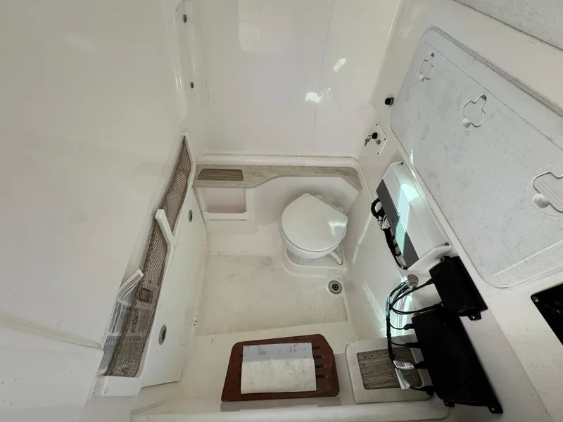 Slide: The Image of Interior of 2017 Everglades 273 Center Console boat, featuring a compact marine toilet. - 34