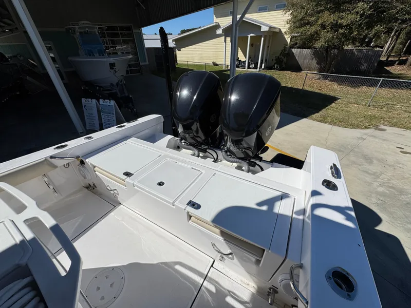 Slide: The Image of 2017 Everglades 273 Center Console boat with dual outboard motors in a sunny outdoor setting. - 43