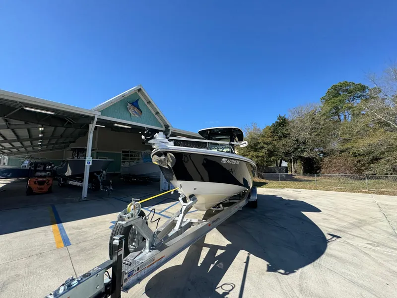 Slide: The Image of 2017 Everglades 273 Center Console boat on trailer, parked outdoors under clear blue sky. - 7