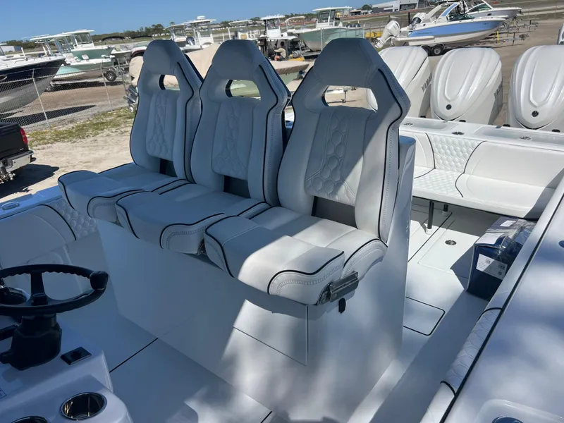 Slide: The Image of 2025 Contender 35 ST boat with three white cushioned seats and steering wheel. - 14