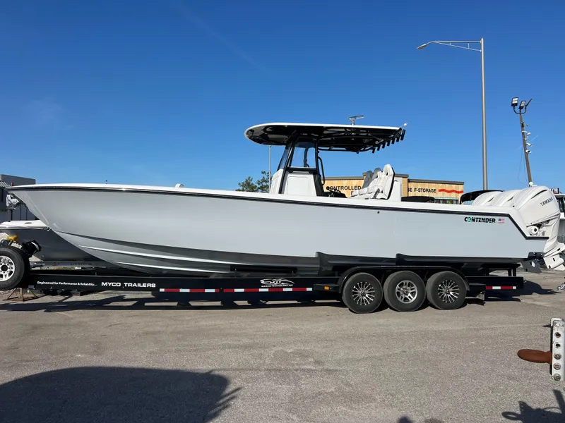 Slide: The Image of 2025 Contender 35 ST boat on trailer, side view, under clear blue sky. - 2