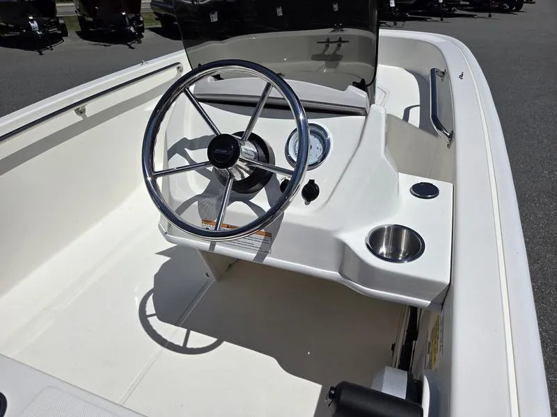 Slide: The Image of 2025 Boston Whaler 130 Super Sport boat interior with steering wheel and dashboard. - 12