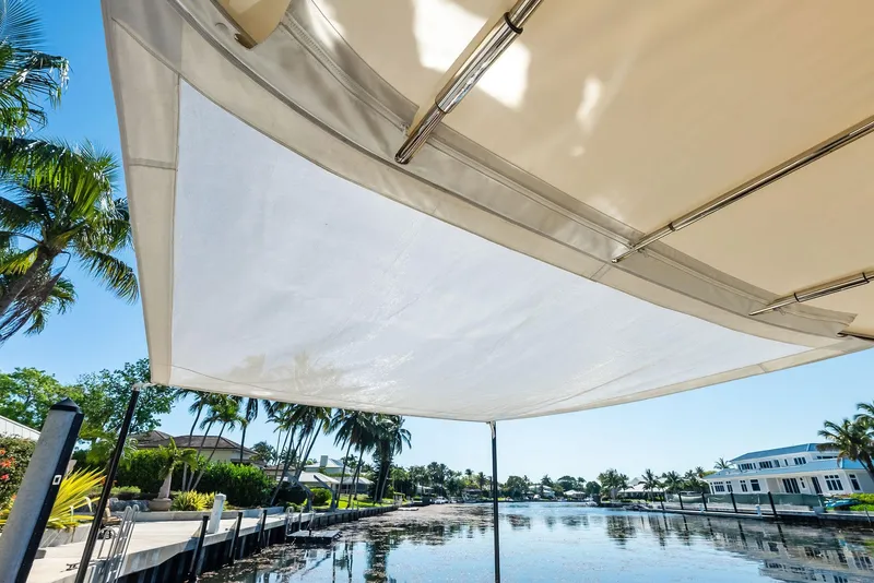 Slide: The Image of Sunny waterfront view from a 2019 Zeelander 55 yacht, featuring a shaded deck area. - 16