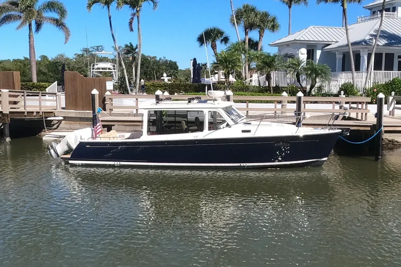 Slide: The Image of 2018 MJM 35z boat docked by a waterfront home with palm trees. - 0