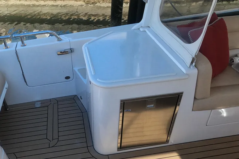 Slide: The Image of 2018 MJM 35z boat interior with teak flooring and compact kitchenette. - 15