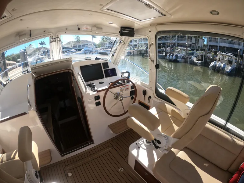 Slide: The Image of Interior of 2018 MJM 35z yacht with helm, seating, and marina view. - 18