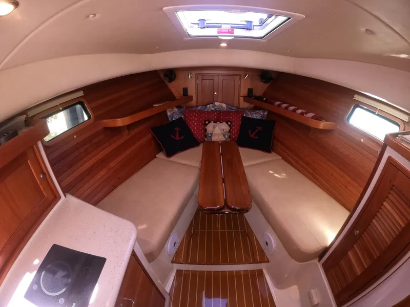 Slide: The Image of 2018 MJM 35z boat interior with wooden finish, cozy seating, and nautical-themed cushions. - 22