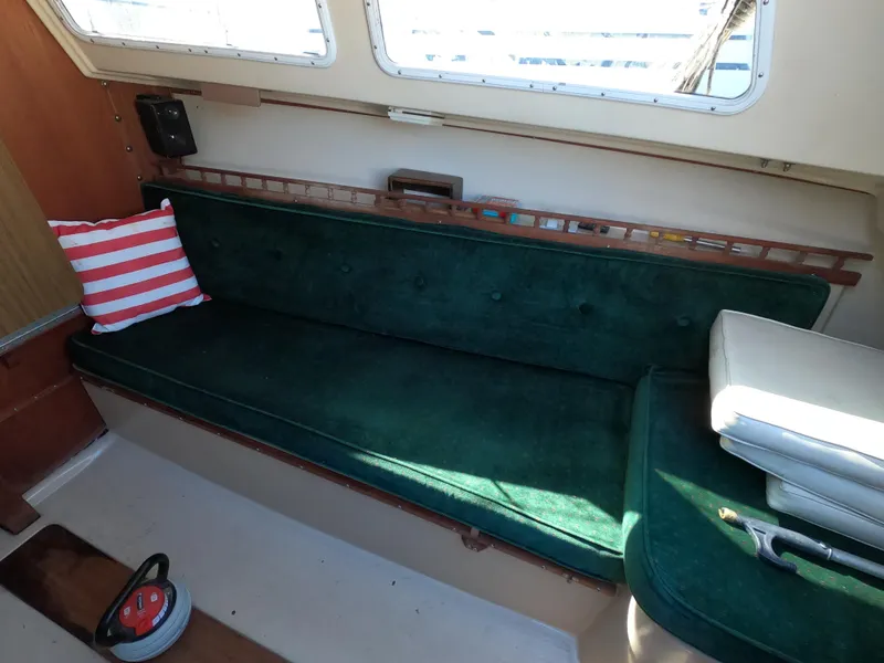Slide: The Image of Interior of 1983 Catalina 27 sailboat with green seating and striped pillow. - 10