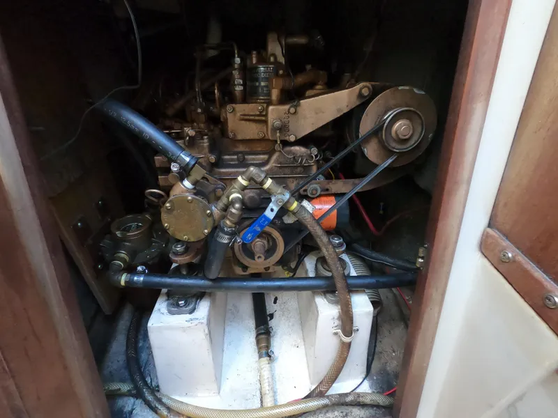 Slide: The Image of Engine compartment of a 1983 Catalina 27 sailboat, showcasing mechanical components and hoses. - 15