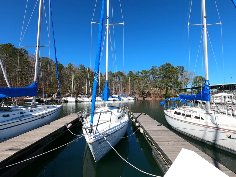 Slide: The Image of Sailboats docked at a marina, featuring a 1983 Catalina 27 under a clear blue sky. - 18