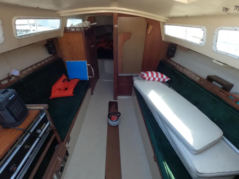 Slide: The Image of Interior of a 1983 Catalina 27 sailboat with green seating and wooden cabinetry. - 5
