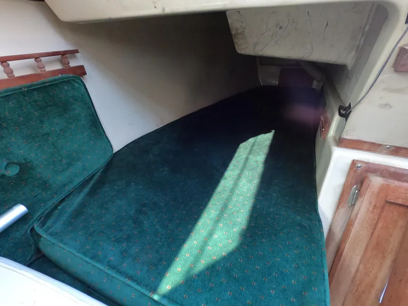 Slide: The Image of Interior cabin of 1983 Catalina 27 sailboat with green cushioned berth. - 6