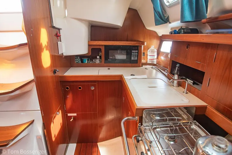 Slide: The Image of Interior of 1995 Beneteau Oceanis 35.1 yacht kitchen with wood finish and modern amenities. - 10