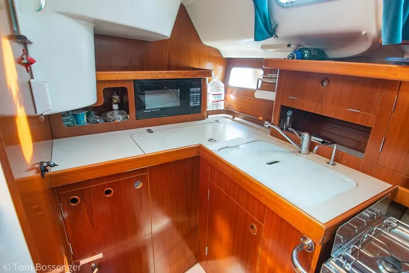 Slide: The Image of Beneteau Oceanis 35.1 1995 yacht kitchen with wood cabinetry and modern appliances. - 12