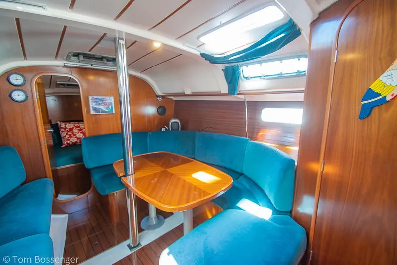 Slide: The Image of Interior of 1995 Beneteau Oceanis 35.1 sailboat with blue seating and wooden table. - 13