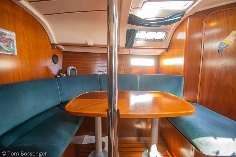 Slide: The Image of Interior of 1995 Beneteau Oceanis 35.1 sailboat with wooden table and blue seating. - 15