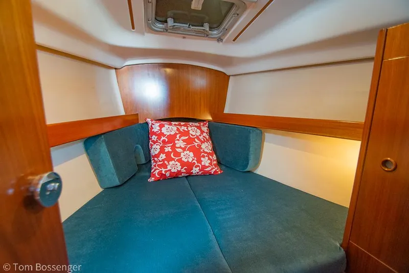 Slide: The Image of Cozy cabin interior of 1995 Beneteau Oceanis 35.1 with blue cushions and floral pillow. - 17