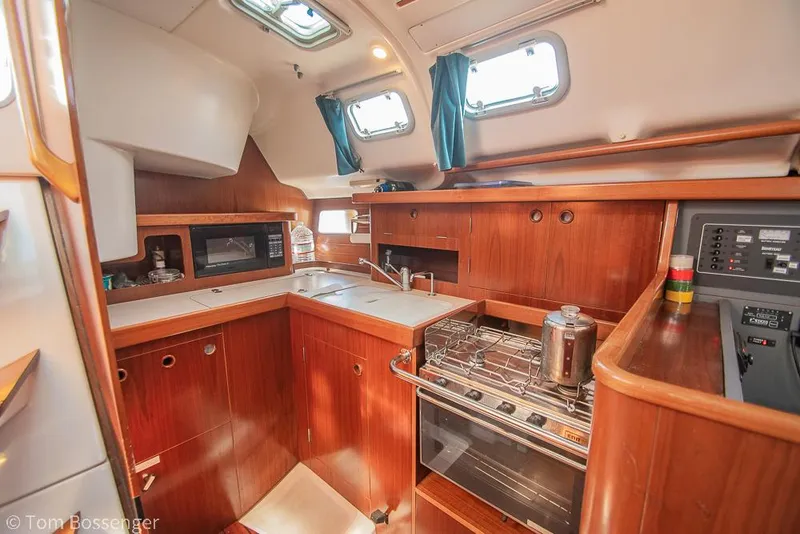 Slide: The Image of Interior of 1995 Beneteau Oceanis 35.1 yacht kitchen with wood cabinetry and modern appliances. - 9