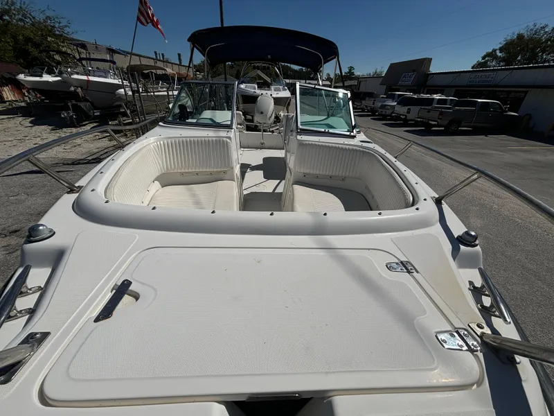 Slide: The Image of 1999 Boston Whaler 20 Ventura Bowrider with open deck and seating, parked outdoors. - 11