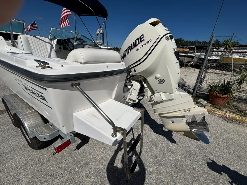 Slide: The Image of 1999 Boston Whaler 20 Ventura Bowrider with Evinrude outboard motor, parked on a trailer. - 13