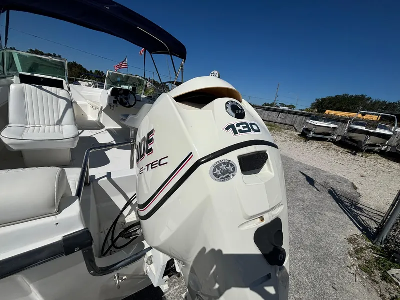 Slide: The Image of 1999 Boston Whaler 20 Ventura Bowrider with Evinrude 130 outboard motor, parked outdoors. - 14
