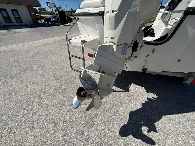 Slide: The Image of 1999 Boston Whaler 20 Ventura Bowrider outboard motor and propeller on pavement. - 15