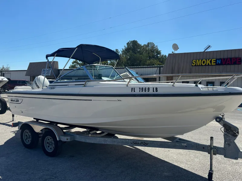 Slide: The Image of 1999 Boston Whaler 20 Ventura Bowrider on trailer, parked near a store. - 2