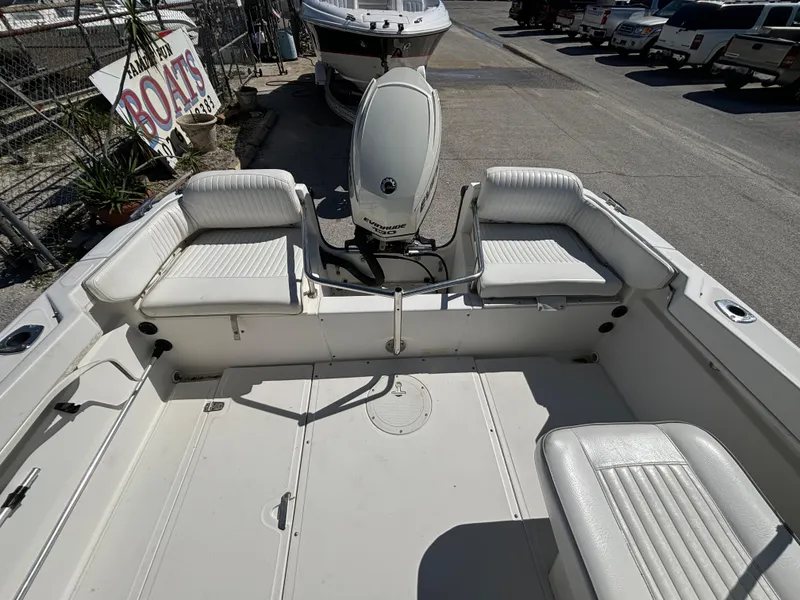 Slide: The Image of 1999 Boston Whaler 20 Ventura Bowrider with white seating and outboard motor in a marina. - 22