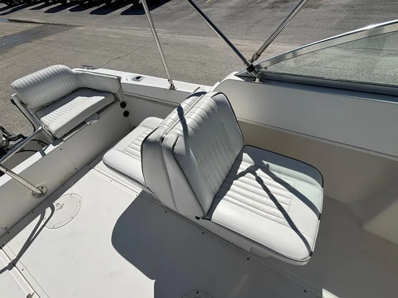 Slide: The Image of 1999 Boston Whaler 20 Ventura Bowrider with white cushioned seating in sunlight. - 28