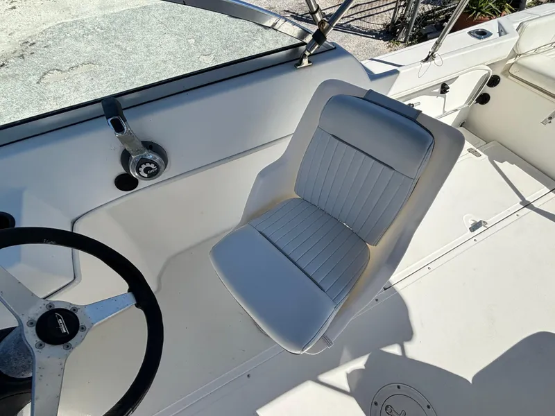 Slide: The Image of 1999 Boston Whaler 20 Ventura Bowrider cockpit with steering wheel and cushioned seat. - 29