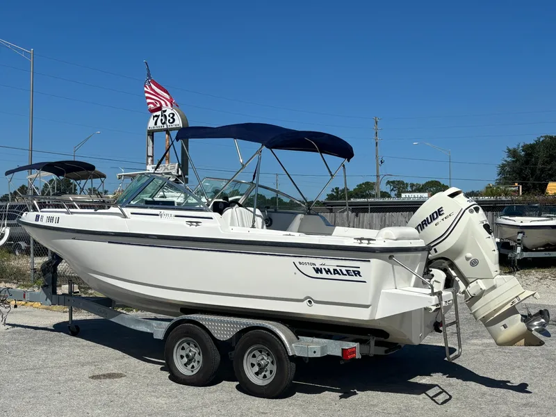 Slide: The Image of 1999 Boston Whaler 20 Ventura Bowrider on trailer, with Evinrude outboard motor and blue canopy. - 4