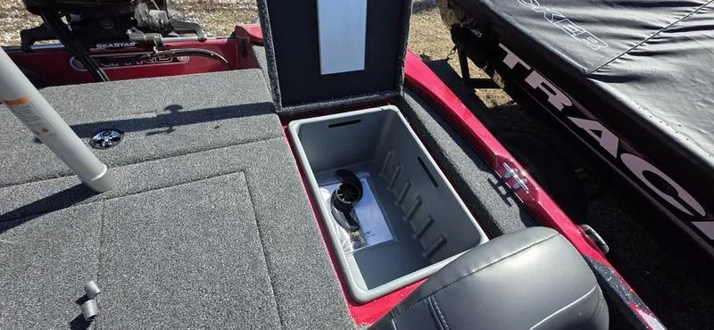 Slide: The Image of Open storage compartment in 2025 Nitro Z17 boat, featuring gray interior and red exterior. - 15