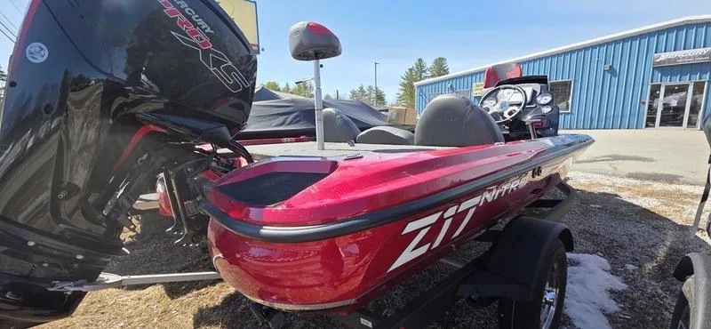 Slide: The Image of 2025 Nitro Z17 boat with outboard motor, parked outdoors near a blue building. - 3